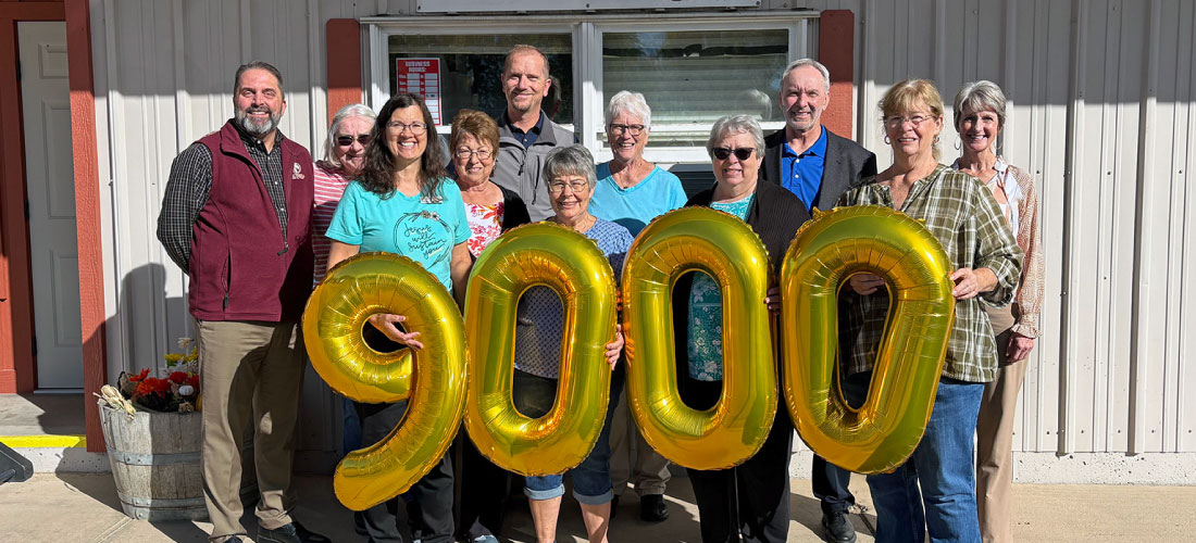 First Federal employees and members of Community Cupboard holding $9000 balloons.