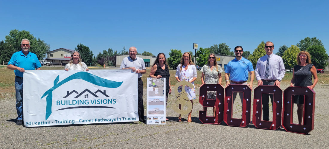 First Federal employees and members of HBA Building Visions holding a banner and marquee numbers.