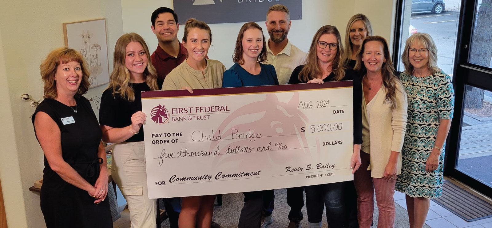 Group of people holding a donation check for Child Bridge