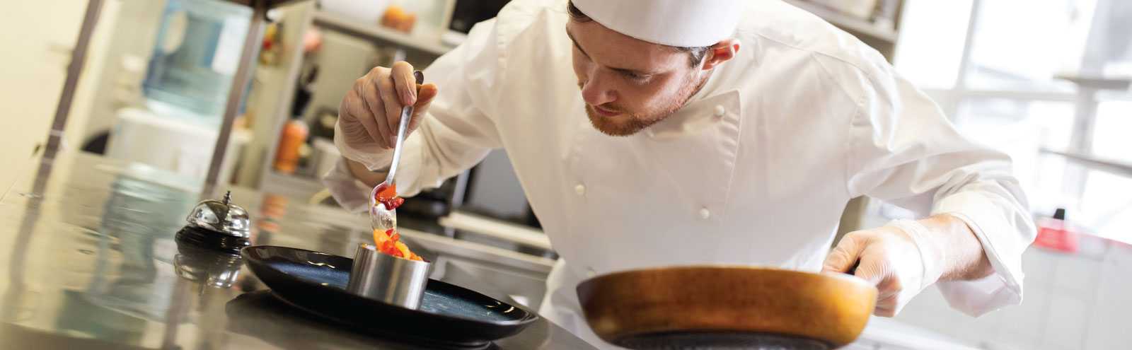 Male chef plating a dish.