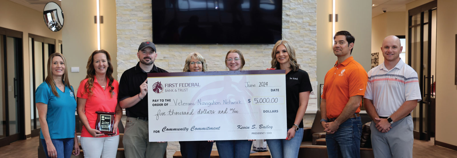 Group of people holding a donation check to Veterans Navigation Network