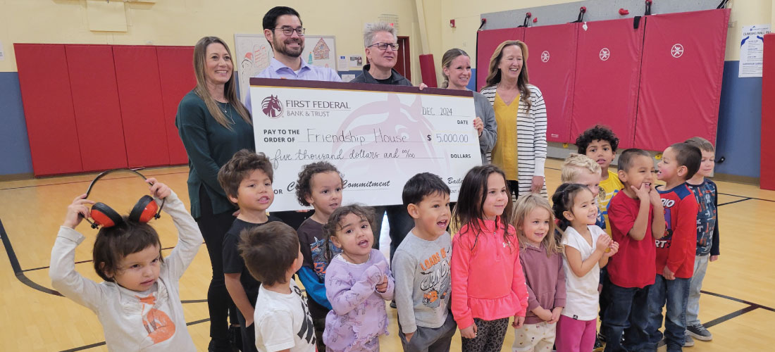 Group of people holding a donation check for Friendship House.