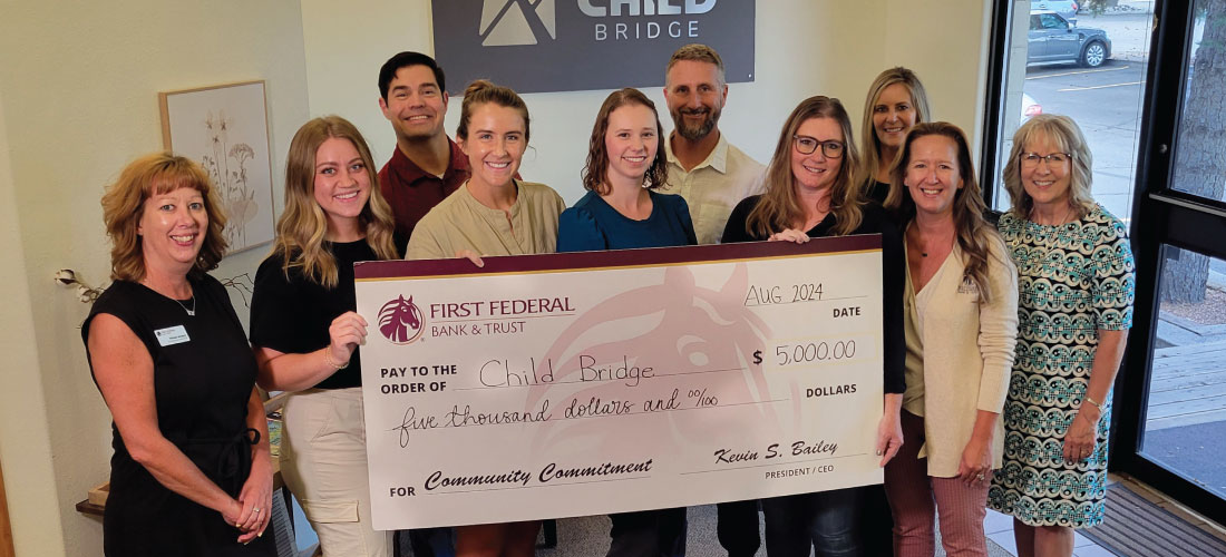 Group of people holding a donation check for Child Bridge.