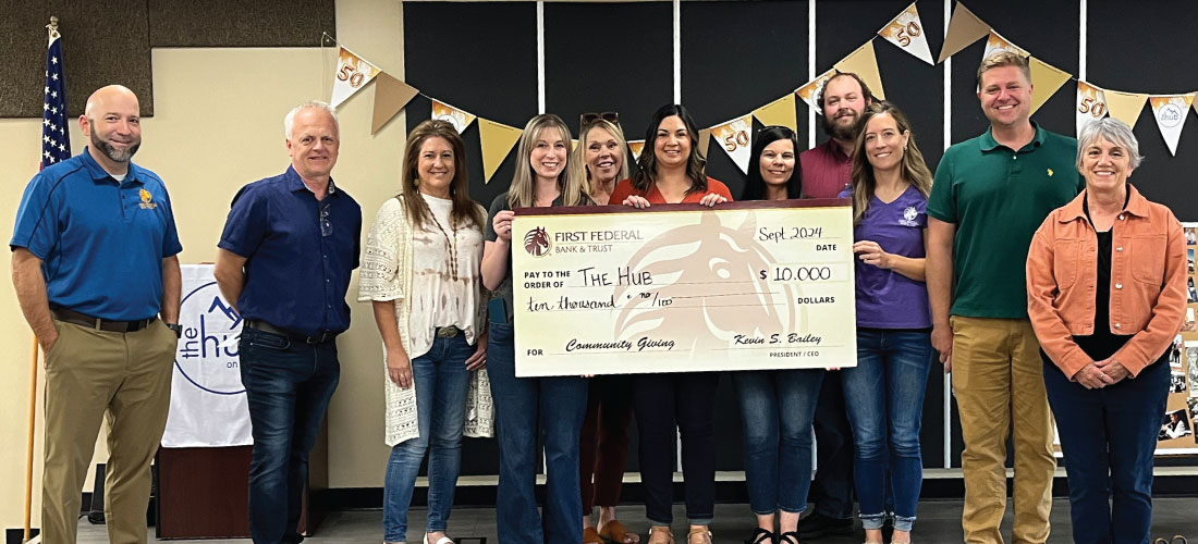 Group of people holding a donation check for the HUB.