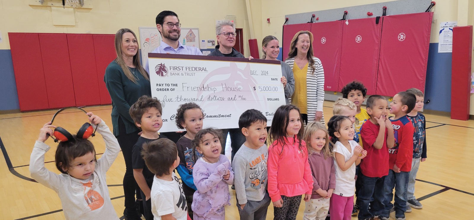 Group of people holding a donation check for Friendship House.