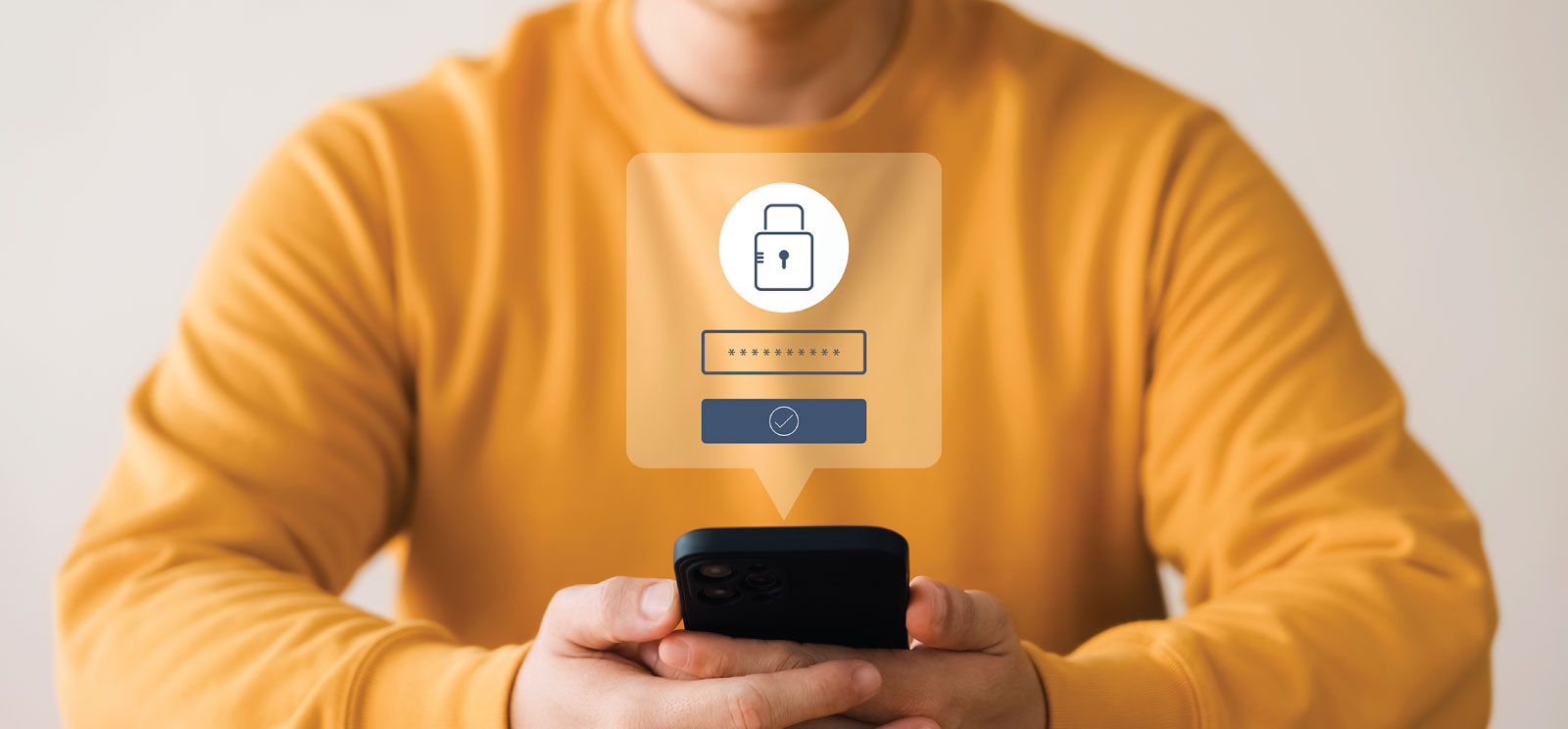 Person in gold sweater holding a mobile phone with login screen above.
