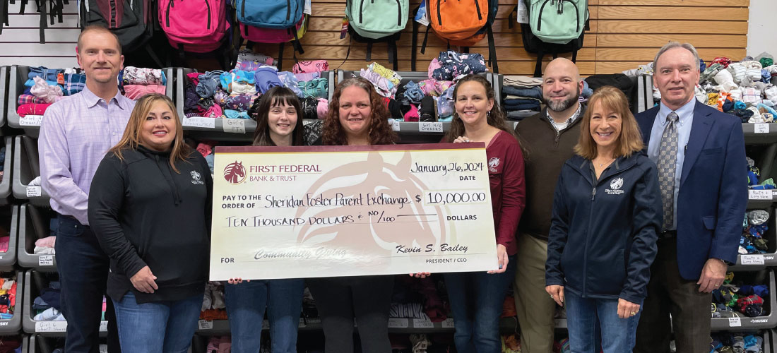 People holding a donation check for Sheridan Foster Parent Exchange