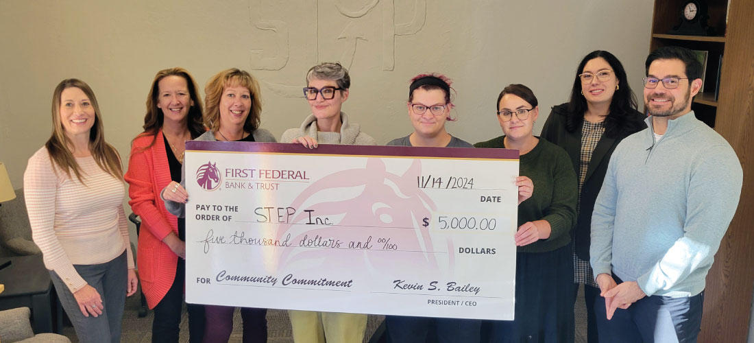 Group of people holding a donation check to STEP, Inc.