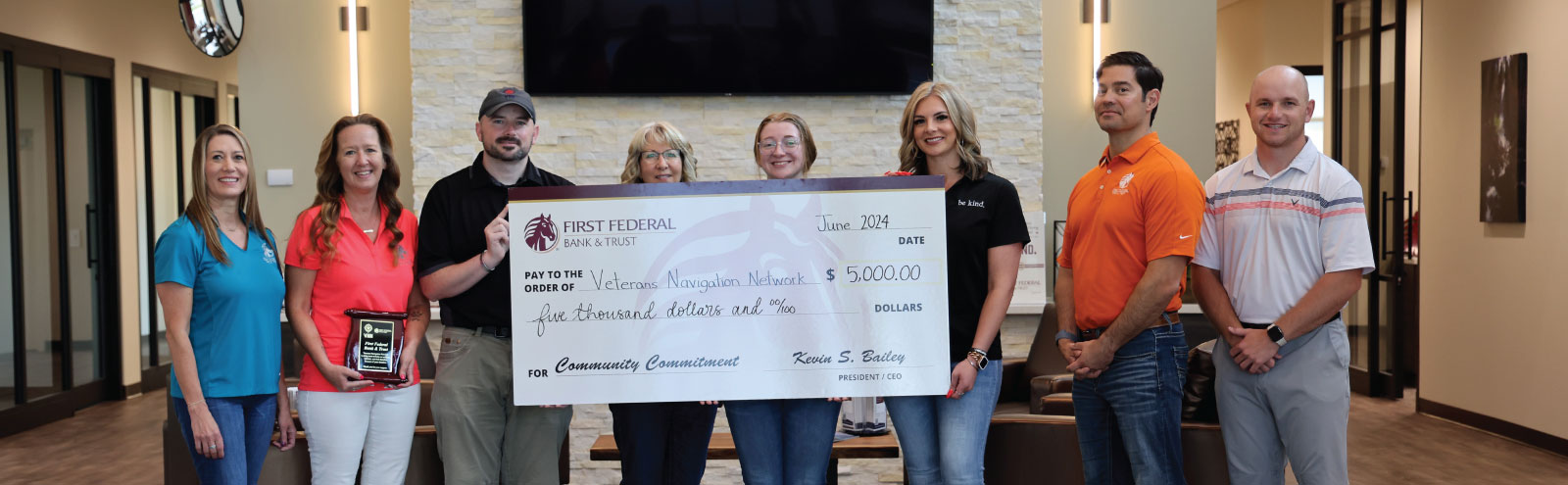 Group of people holding a donation check for Veterans Navigation Network.