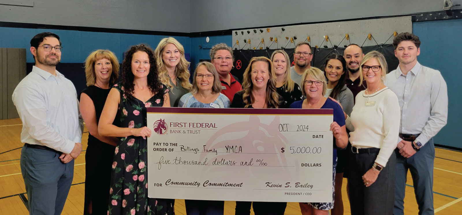 Group of people holding a donation check to the Billings YMCA.