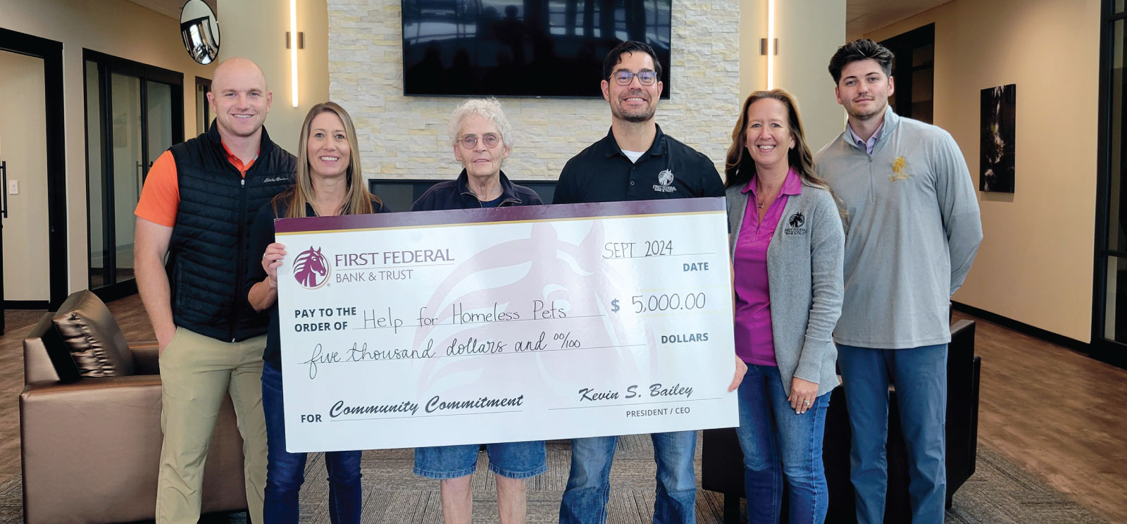 Group of people holding a donation check to Help For Homeless Pets.